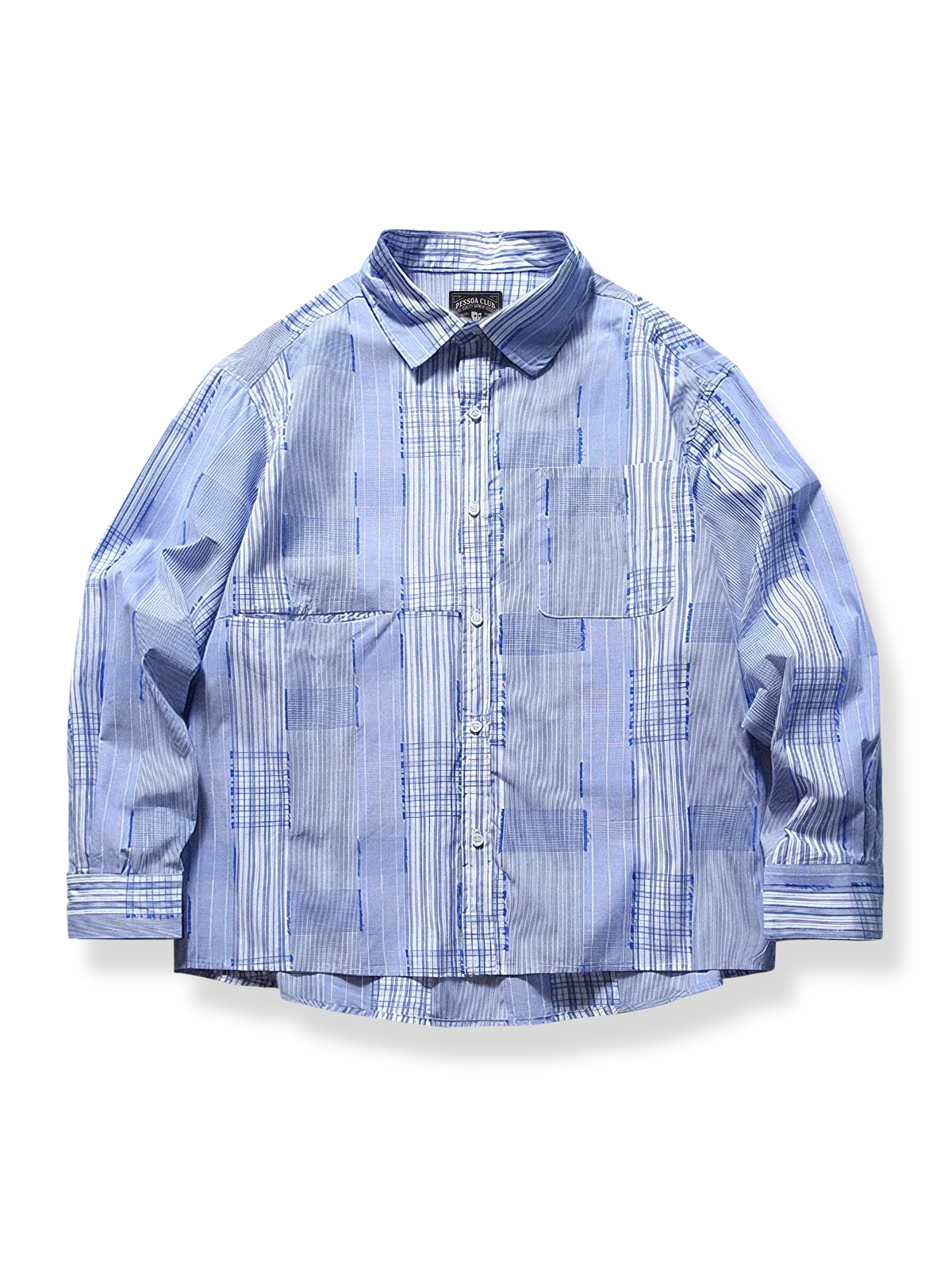 異なる青のチェックをパッチワークで組み合わせた長袖シャツのディテールを捉えたビジュアル。