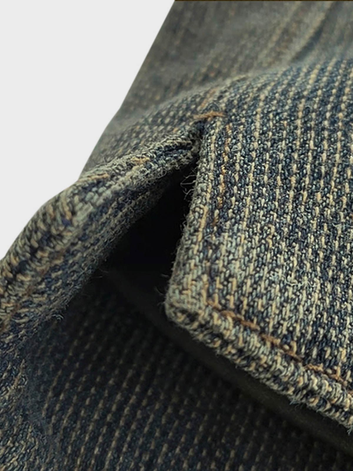 ディテールクローズアップ:紳士スーツカラーベストのシンプルなポケットラインと赤いアクセントのボタンホール、精緻な手触り