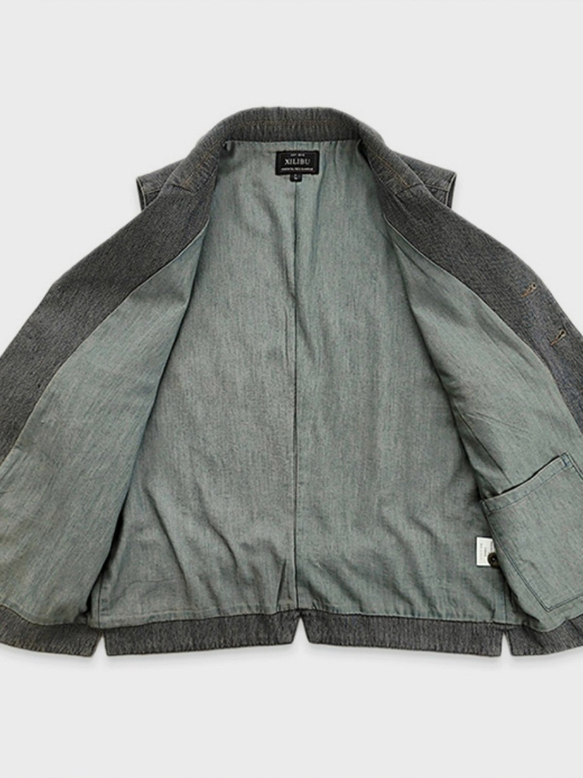 ディテールクローズアップ:紳士スーツカラーベストのシンプルなポケットラインと赤いアクセントのボタンホール、精緻な手触り