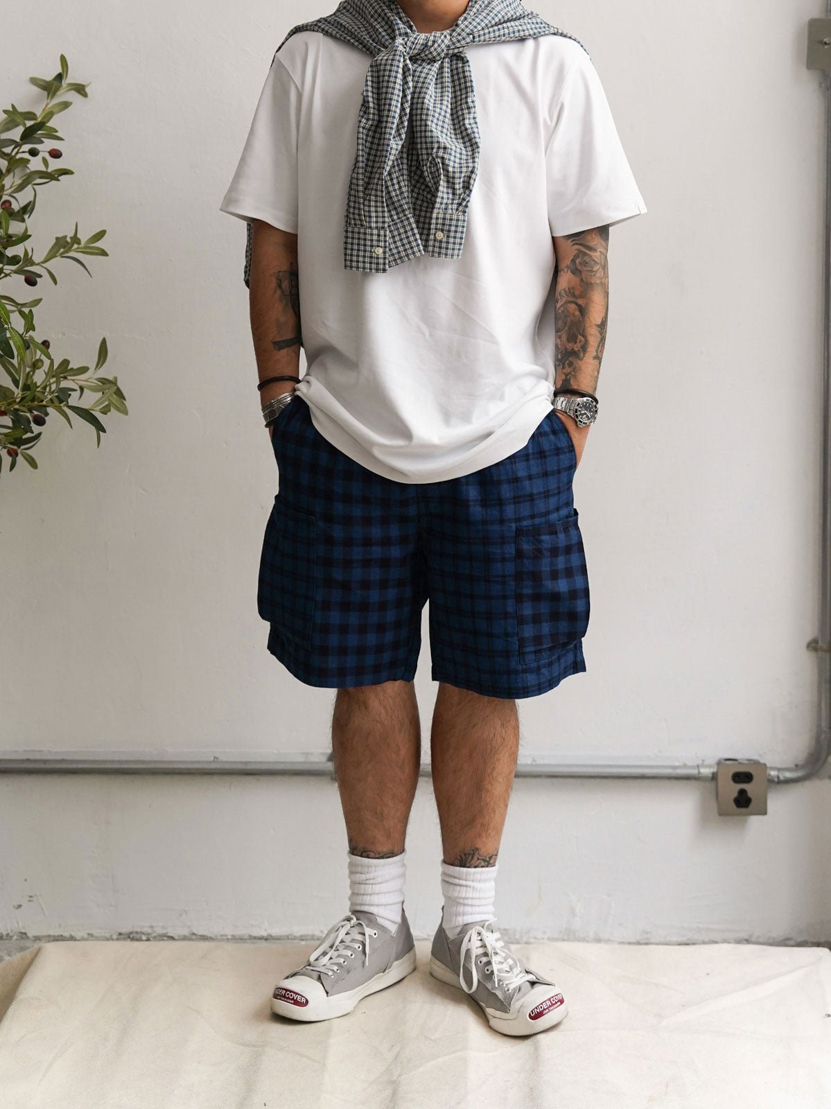 モデル画像: モデルがヴィンテージインディゴアシンメトリーパッチワークチェック多ポケットショーツを着用している様子