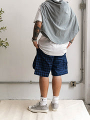 モデル画像: モデルがヴィンテージインディゴアシンメトリーパッチワークチェック多ポケットショーツを着用している様子