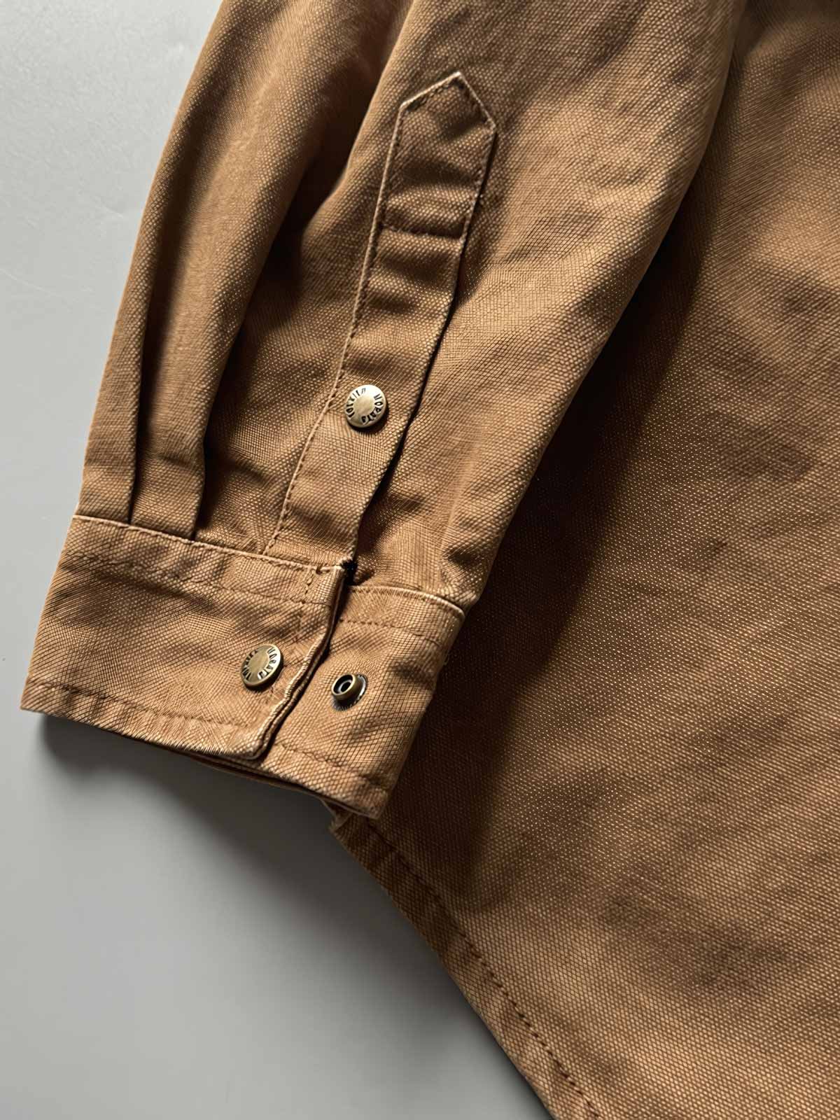 製品画像: アウトドアハンティング(狩猟)スタイルヴィンテージウォッシュ加工ワークシャツの全体画像。シャツの全体的なシルエットとデザインが明確に分かる。
詳細画像: ダブルポケットのデザインとヴィンテージ加工のディテール画像。シャツの質感と耐久性が強調されている。