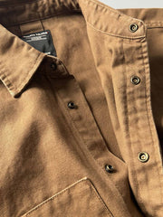 製品画像: アウトドアハンティング(狩猟)スタイルヴィンテージウォッシュ加工ワークシャツの全体画像。シャツの全体的なシルエットとデザインが明確に分かる。
詳細画像: ダブルポケットのデザインとヴィンテージ加工のディテール画像。シャツの質感と耐久性が強調されている。