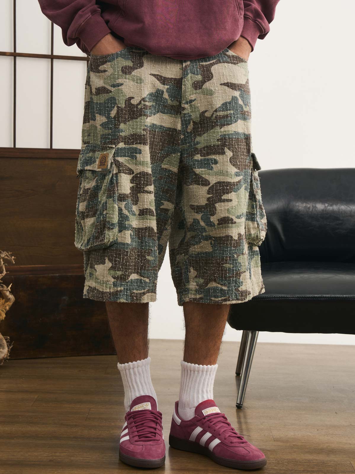 モデルが迷彩七分丈パンツを着用し、カジュアルなトップスと組み合わせた個性的なヴィンテージスタイルを演出。