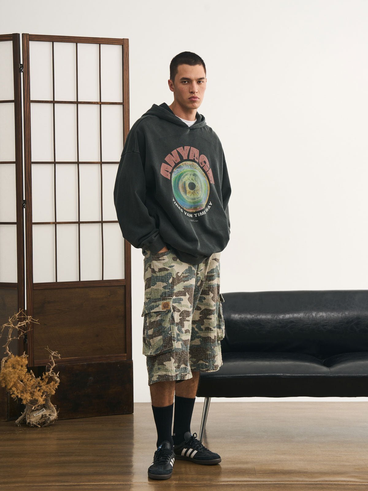 モデルが迷彩七分丈パンツを着用し、カジュアルなトップスと組み合わせた個性的なヴィンテージスタイルを演出。