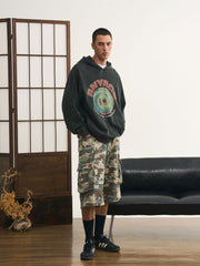 モデルが迷彩七分丈パンツを着用し、カジュアルなトップスと組み合わせた個性的なヴィンテージスタイルを演出。