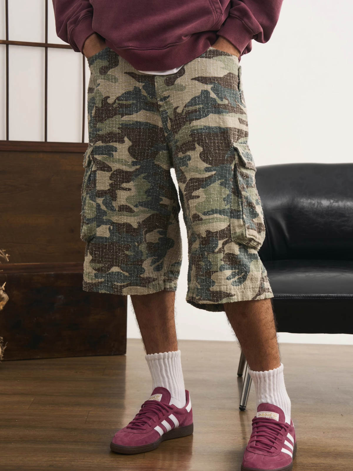 モデルが迷彩七分丈パンツを着用し、カジュアルなトップスと組み合わせた個性的なヴィンテージスタイルを演出。