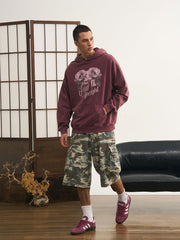 モデルが迷彩七分丈パンツを着用し、カジュアルなトップスと組み合わせた個性的なヴィンテージスタイルを演出。