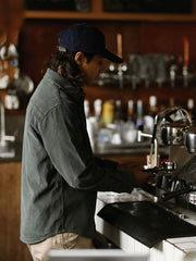 詳細画像: ラウンドヘムとヴィンテージ風ボタンのディテールクローズアップ
モデル画像: コーデュロイシャツを着用したスタイリング例