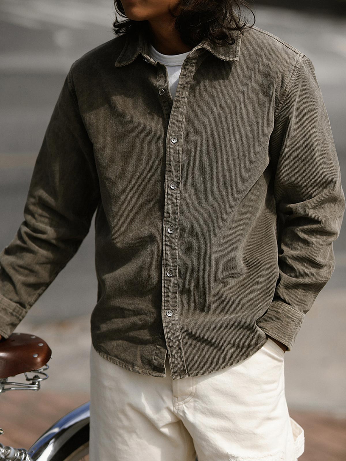 詳細画像: ラウンドヘムとヴィンテージ風ボタンのディテールクローズアップ
モデル画像: コーデュロイシャツを着用したスタイリング例