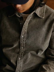 詳細画像: ラウンドヘムとヴィンテージ風ボタンのディテールクローズアップ
モデル画像: コーデュロイシャツを着用したスタイリング例