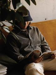 詳細画像: ラウンドヘムとヴィンテージ風ボタンのディテールクローズアップ
モデル画像: コーデュロイシャツを着用したスタイリング例