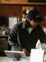 詳細画像: ラウンドヘムとヴィンテージ風ボタンのディテールクローズアップ
モデル画像: コーデュロイシャツを着用したスタイリング例