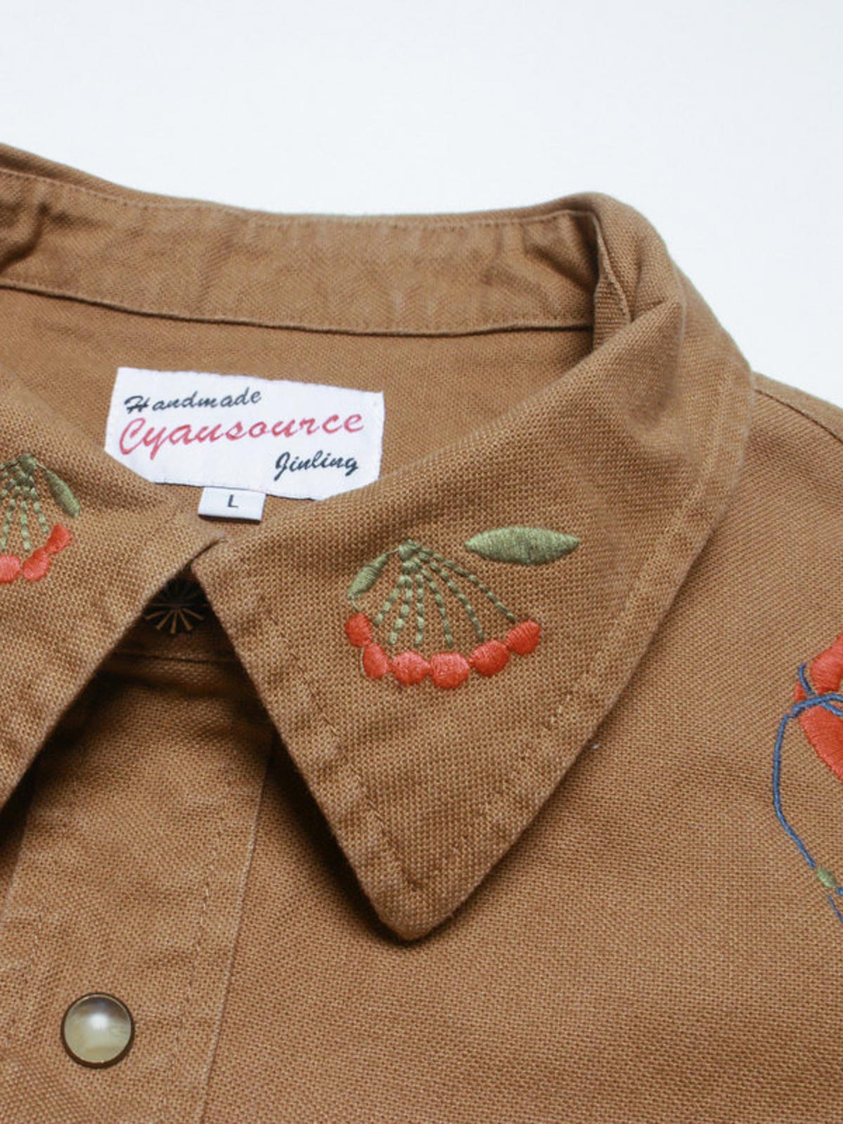 コットン刺繍と金属製ボタンのディテール特写