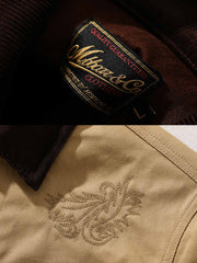 製品画像: オイルワックスジュファブリックのアメリカンビンテージライダースジャケット平置き画像 - 防風・保温デザイン
詳細画像: ヴィンテージ刺繍とコーデュロイ襟のディテール - レイヤー感とヴィンテージスタイル