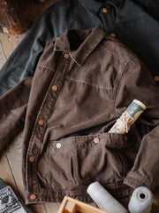 製品画像:アメカジヴィンテージウォッシュ加工ワークジャケットの正面展示。ヴィンテージ感とワークウェアの機能性が融合した一着。
詳細画像:ヴィンテージメタルボタンとダブルステッチのディテール。耐久性とデザイン性を兼ね備えたディテール。