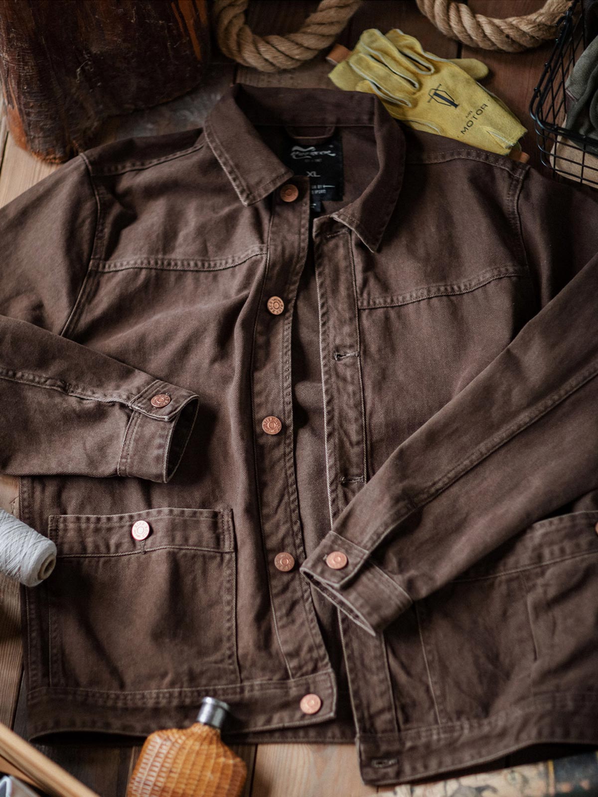 製品画像:アメカジヴィンテージウォッシュ加工ワークジャケットの正面展示。ヴィンテージ感とワークウェアの機能性が融合した一着。
詳細画像:ヴィンテージメタルボタンとダブルステッチのディテール。耐久性とデザイン性を兼ね備えたディテール。