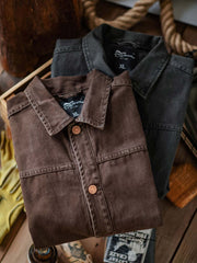 製品画像:アメカジヴィンテージウォッシュ加工ワークジャケットの正面展示。ヴィンテージ感とワークウェアの機能性が融合した一着。
詳細画像:ヴィンテージメタルボタンとダブルステッチのディテール。耐久性とデザイン性を兼ね備えたディテール。