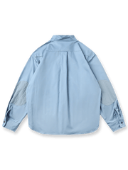 製品画像: クラシックなスタンドカラーと肘パッチが特徴のワークシャツ。シンプルでありながらスタイリッシュなデザインが際立っています。
詳細画像: 非対称ポケットと肘パッチが施されたディテール。デザインと機能性が融合した袖部分が強調されています。