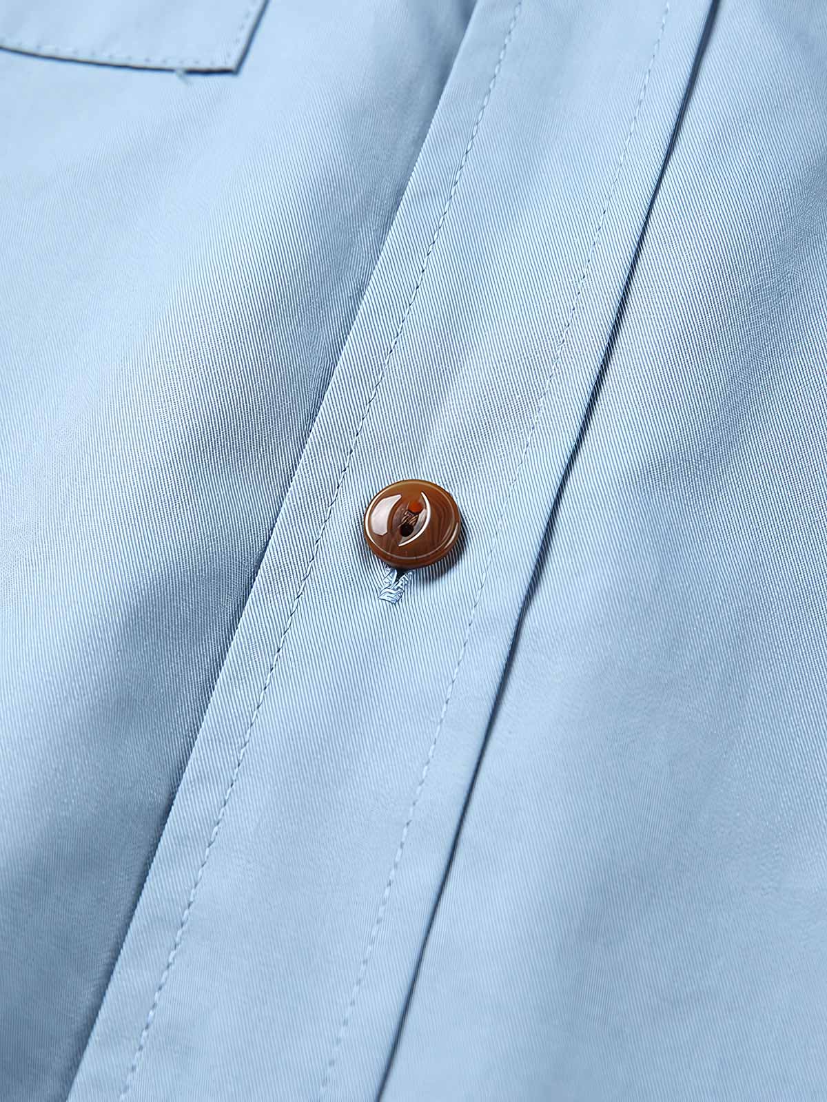 製品画像: クラシックなスタンドカラーと肘パッチが特徴のワークシャツ。シンプルでありながらスタイリッシュなデザインが際立っています。
詳細画像: 非対称ポケットと肘パッチが施されたディテール。デザインと機能性が融合した袖部分が強調されています。