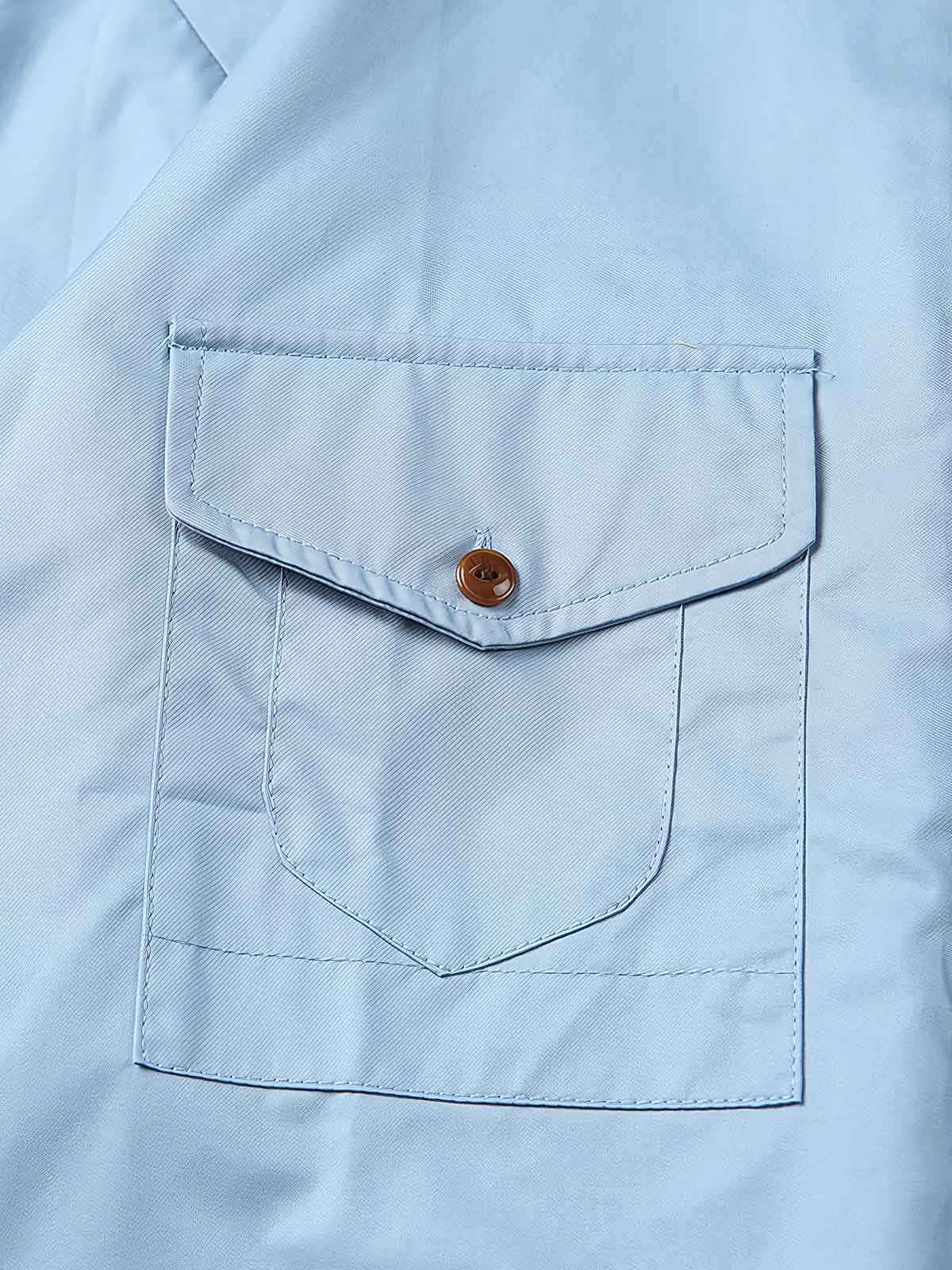 製品画像: クラシックなスタンドカラーと肘パッチが特徴のワークシャツ。シンプルでありながらスタイリッシュなデザインが際立っています。
詳細画像: 非対称ポケットと肘パッチが施されたディテール。デザインと機能性が融合した袖部分が強調されています。