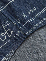 デニム半袖シャツの文字プリントディテール。厳選されたデニム素材と高品質なウォッシュ加工が施され、洗練された外見と耐久性を実現しています。