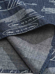 デニム半袖シャツの文字プリントディテール。厳選されたデニム素材と高品質なウォッシュ加工が施され、洗練された外見と耐久性を実現しています。