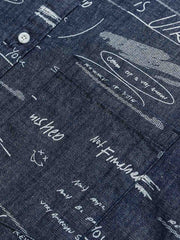 デニム半袖シャツの文字プリントディテール。厳選されたデニム素材と高品質なウォッシュ加工が施され、洗練された外見と耐久性を実現しています。