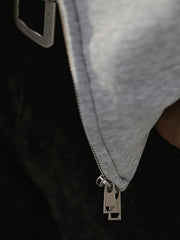 製品画像: グレーのエアレイヤースタイルカットフード付きパーカの正面展示
詳細画像: ダブルジップメタルファスナーと三角カットデザインのディテール展示