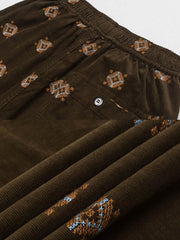 パンツのトーテム刺繍部分のクローズアップ。