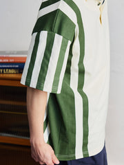 ポロシャツの草緑色ボタンと襟のディテールを特集し、洗練された作りを示す。