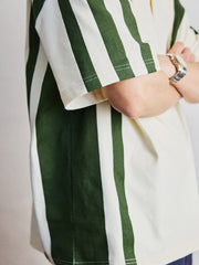 ポロシャツの草緑色ボタンと襟のディテールを特集し、洗練された作りを示す。