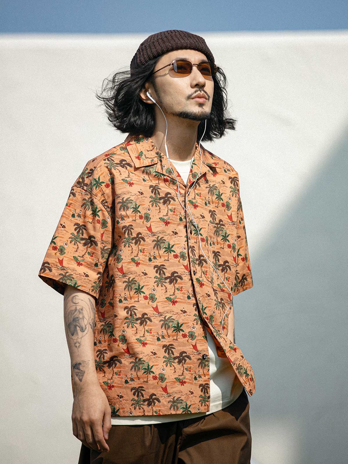 モデルがサンセットビーチプリント半袖シャツを着用し、カジュアルパンツと合わせた様々なアングルを展示