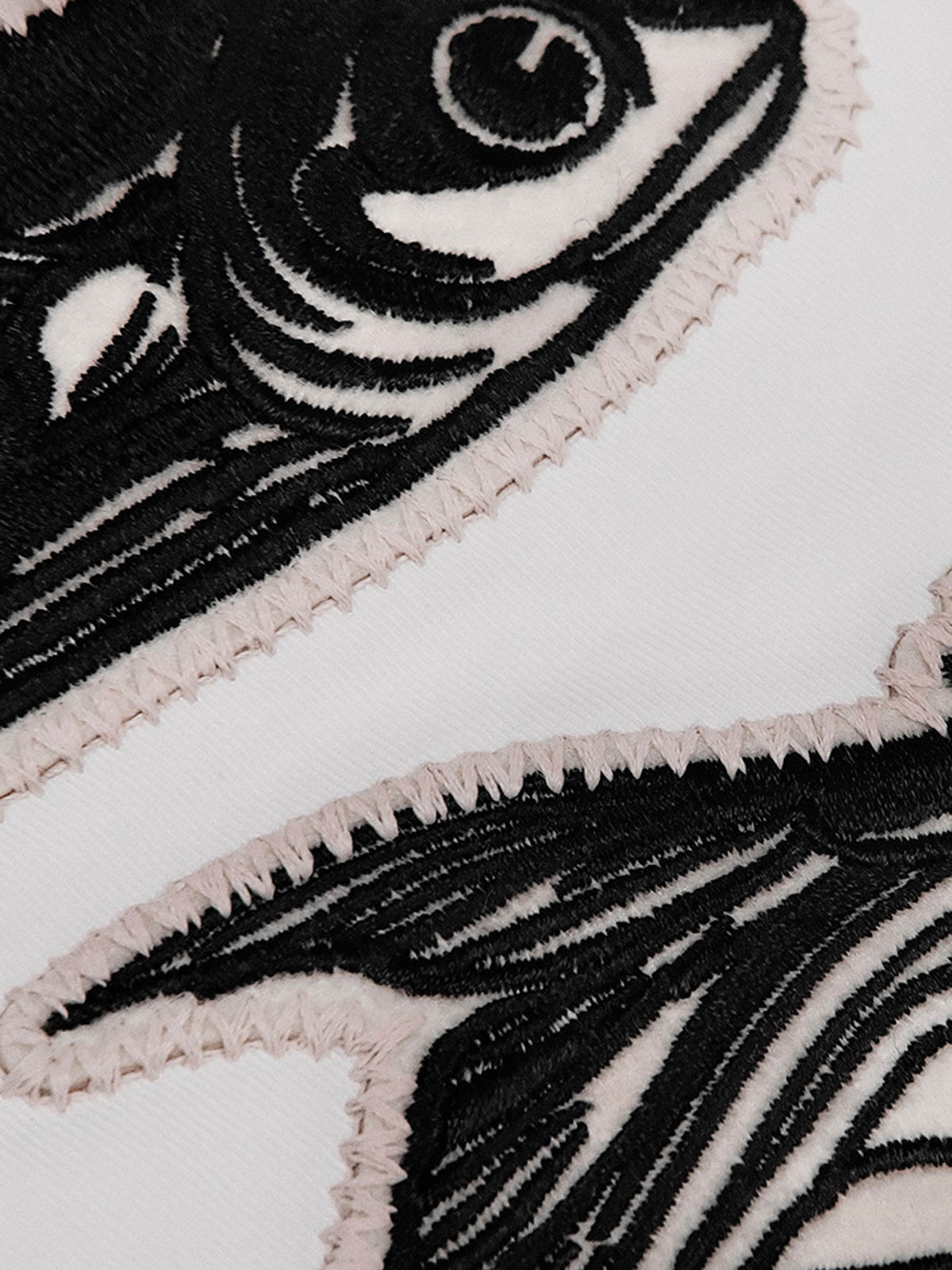 詳細画像: 前面の大きなポケットと背中の刺繍のディテール