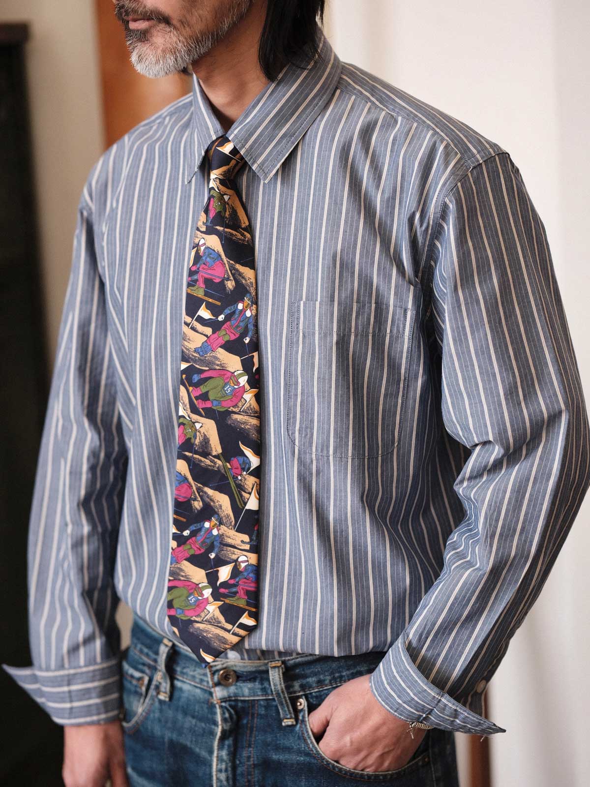 产品图:シルククロスカントリースキープリントネクタイの全体像 细节图:ネクタイのクロスカントリースキープリントのクローズアップ 模特图:モデルがシルククロスカントリースキープリントネクタイを着用しているシーン