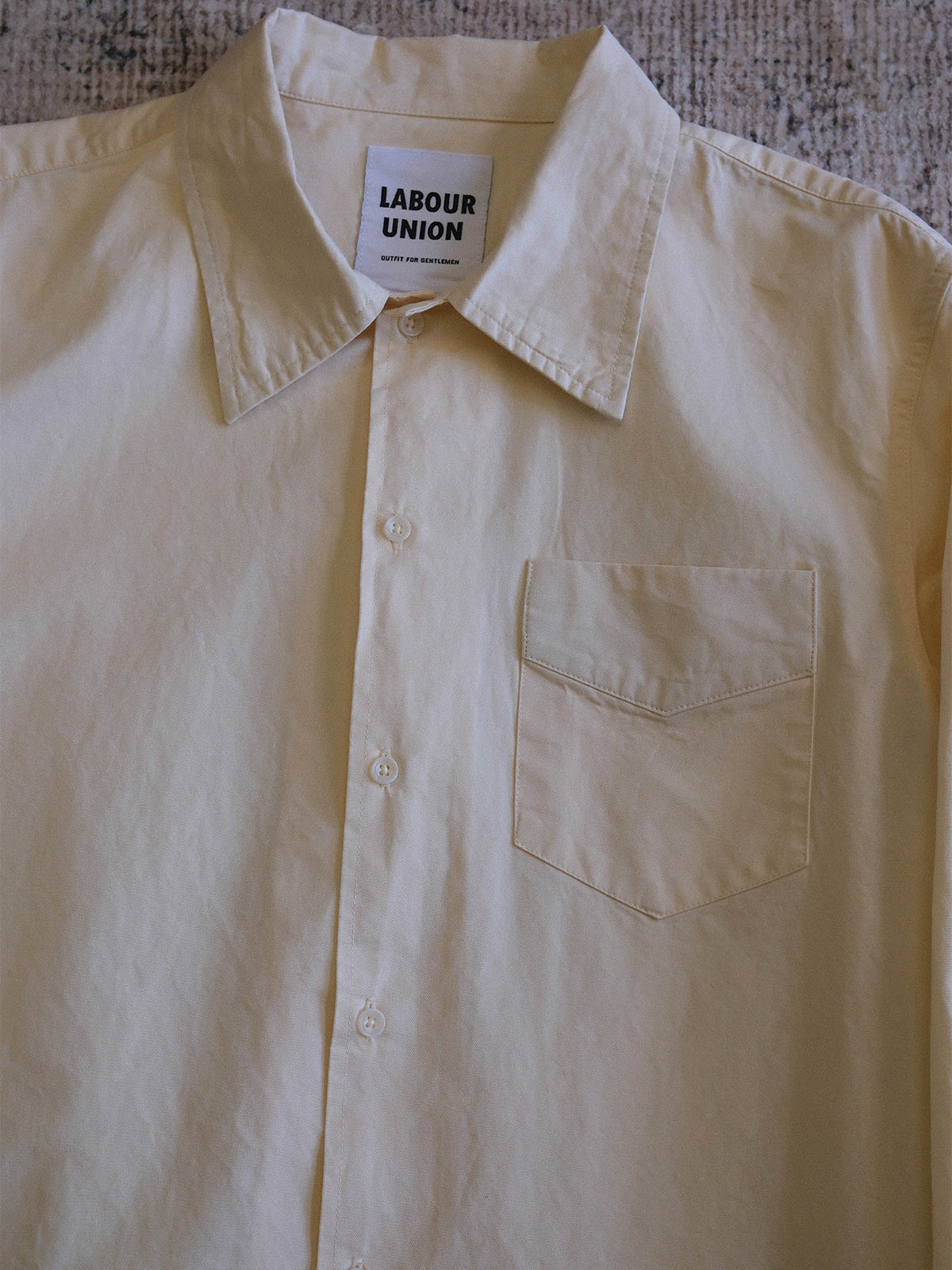 製品画像: 100%コットンのクラシックルーズフィット長袖シャツ、ホワイト、フロントビュー
詳細画像: クラシックルーズフィット長袖シャツの高品質な縫製と樹脂ボタンのディテール