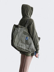 Happyendキャンバストートバッグを持つモデル、1970年代軍事スタイルとハワイパターンで日常使いに適したデザイン