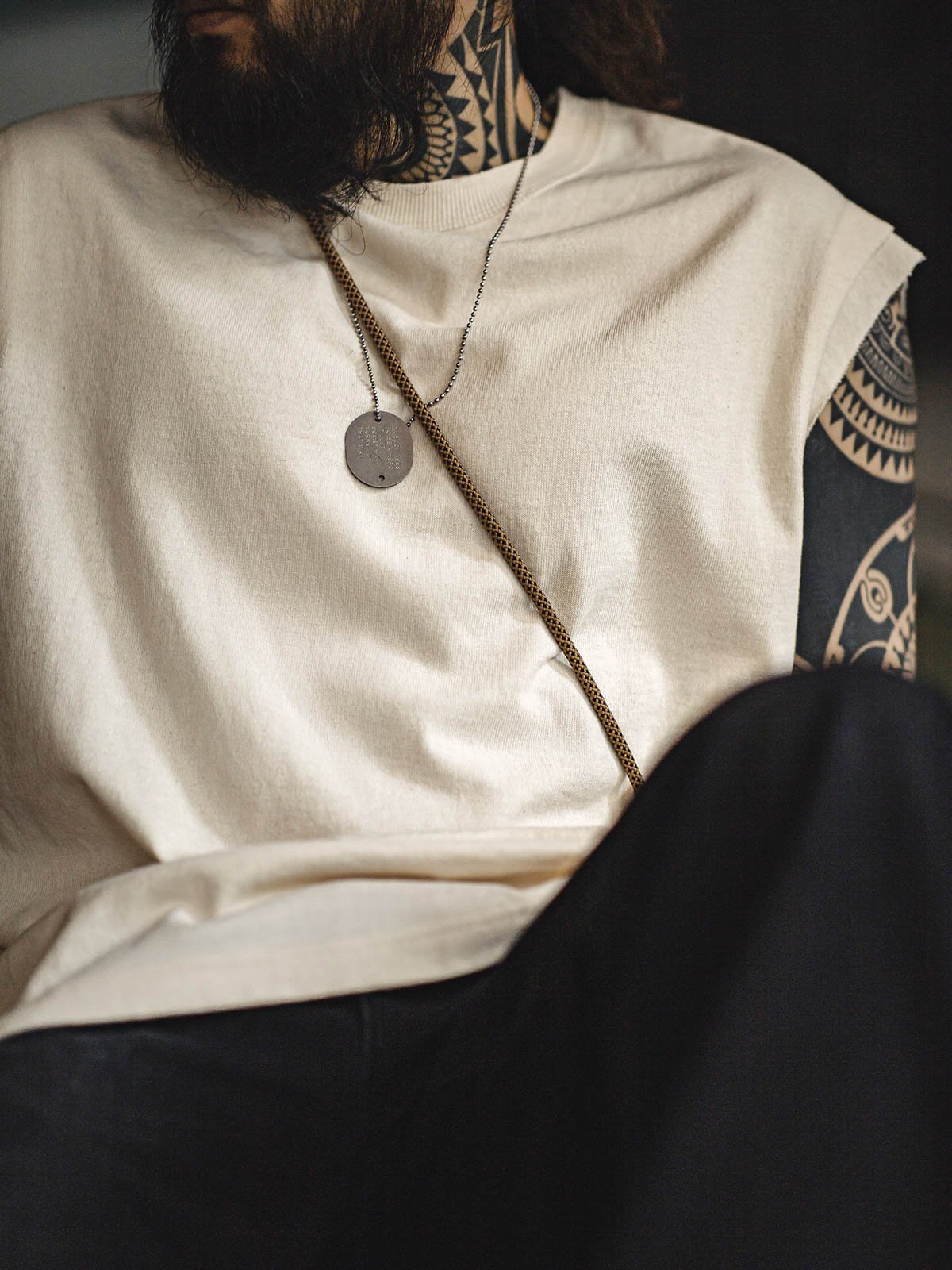 モデルがヘビーウェイトコットンハスクのスリーブレスTシャツを着用し、ルーズフィットのショートパンツとスポーツシューズでスタイリング。リラックスしたカリフォルニアの夏のスタイルを演出しています。