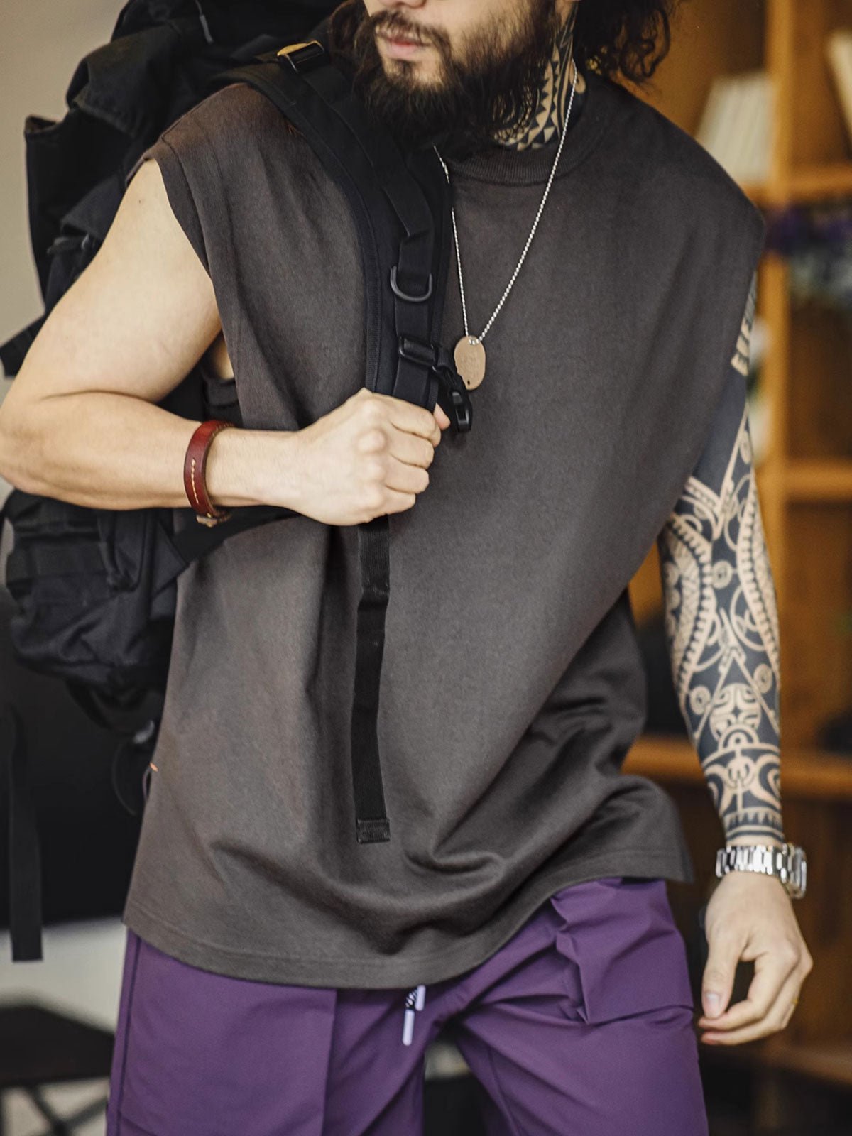 モデルがヘビーウェイトコットンハスクのスリーブレスTシャツを着用し、ルーズフィットのショートパンツとスポーツシューズでスタイリング。リラックスしたカリフォルニアの夏のスタイルを演出しています。