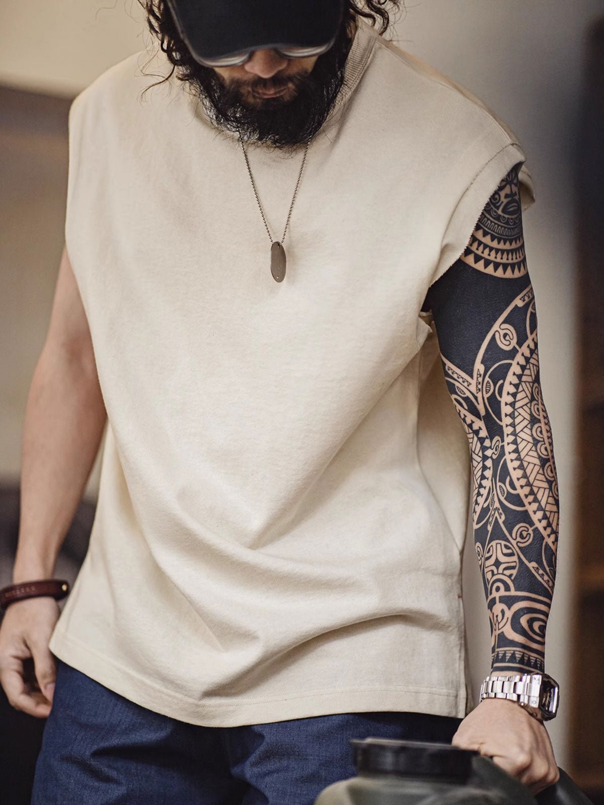 モデルがヘビーウェイトコットンハスクのスリーブレスTシャツを着用し、ルーズフィットのショートパンツとスポーツシューズでスタイリング。リラックスしたカリフォルニアの夏のスタイルを演出しています。