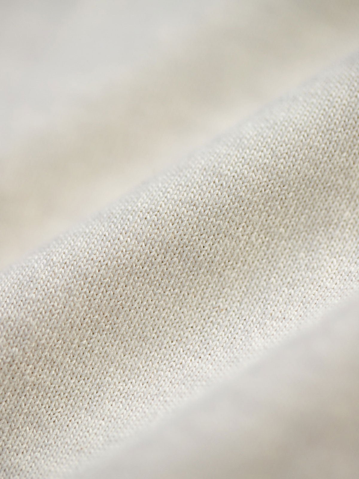 ヘビーウェイトのコットンハスク素材の詳細とダブルレイヤーのアームホールのクローズアップ。素材の厚みと耐摩耗性を強調し、デザインの階層感を示しています。