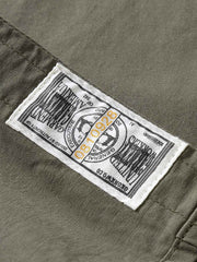 エンジニア半袖シャツのツイルコットンとヴィンテージボタンのクローズアップ。