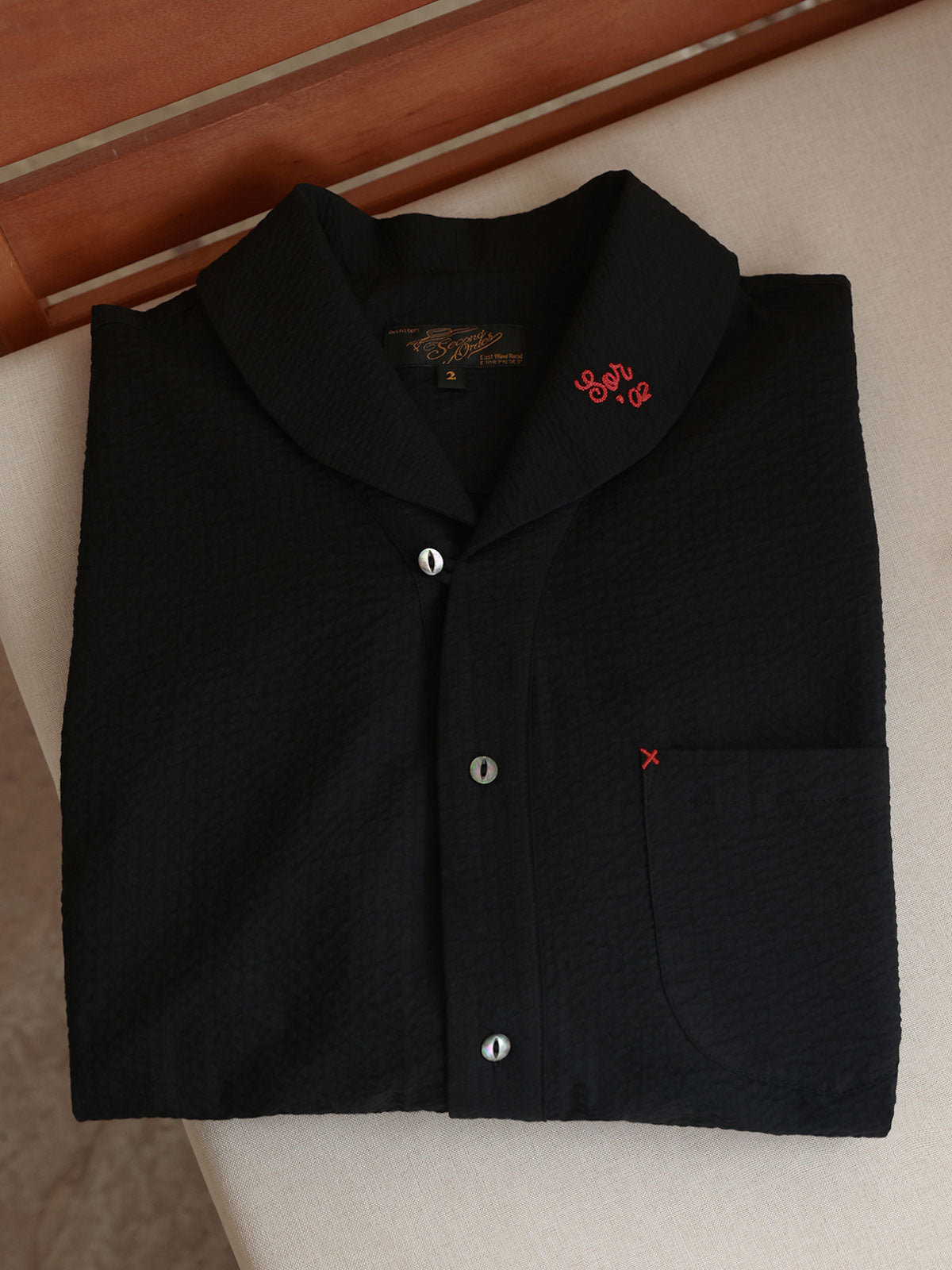 シャツの胸ポケットとコントラストカラーの補強ステッチのクローズアップ