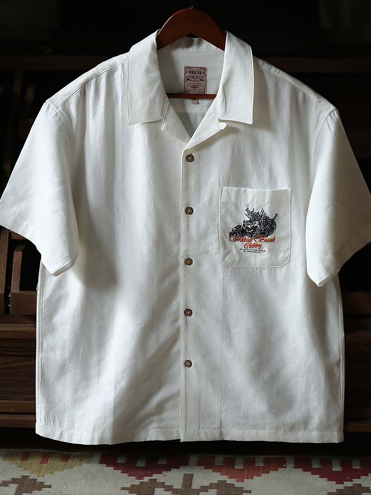 細部にわたるドラゴンの発泡プリント刺繍を特徴とするシャツのクローズアップ。