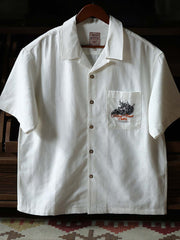 細部にわたるドラゴンの発泡プリント刺繍を特徴とするシャツのクローズアップ。