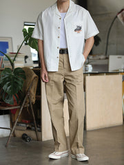 モデルがリネンパンツと合わせて着用するスカルドラゴン刺繍キューバンシャツ。