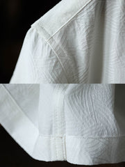 細部にわたるドラゴンの発泡プリント刺繍を特徴とするシャツのクローズアップ。