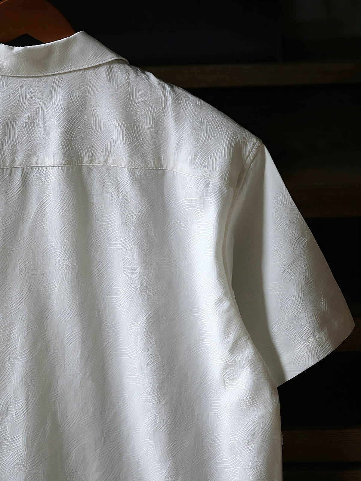 細部にわたるドラゴンの発泡プリント刺繍を特徴とするシャツのクローズアップ。