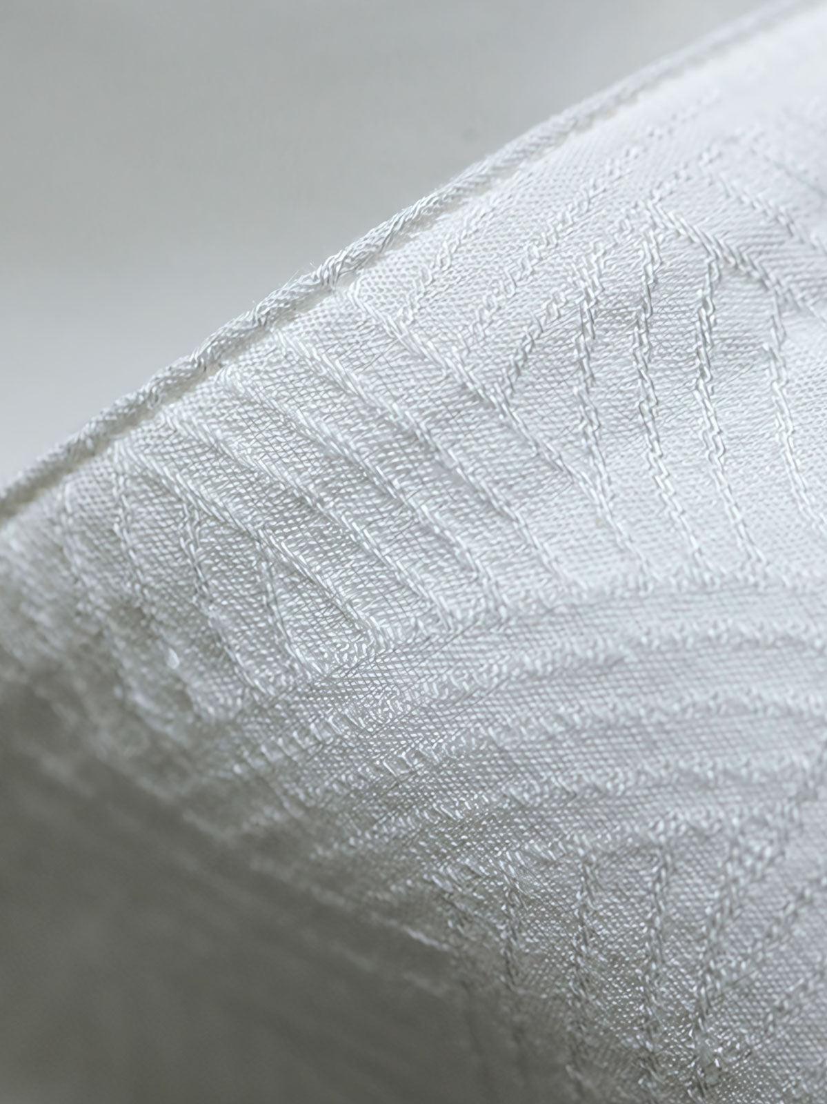 細部にわたるドラゴンの発泡プリント刺繍を特徴とするシャツのクローズアップ。