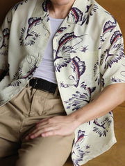 モデルがカジキプリントのハワイアンシャツを着用し、リラックスした夏のスタイリングを展示しています。